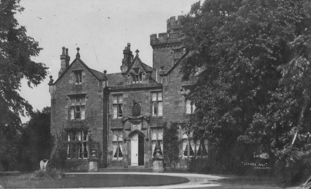 Historic black-and-white photograph of the castellated Storrs Hall at Arkholme, with its embattled tower, gables and tall chimneys, partly hidden by trees